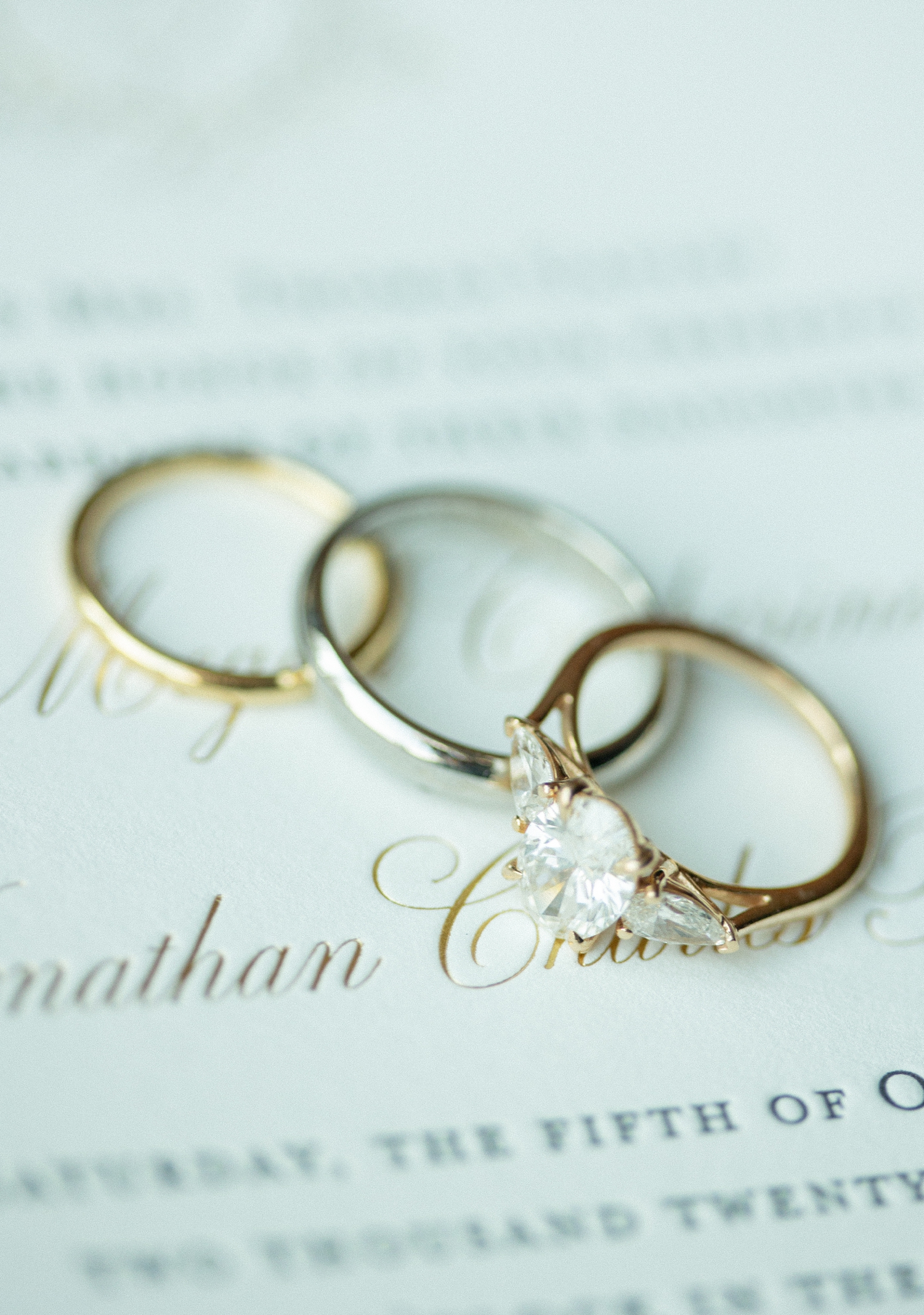 Rings sitting on invitation to show Revel motor row wedding, photography by Allison Francois