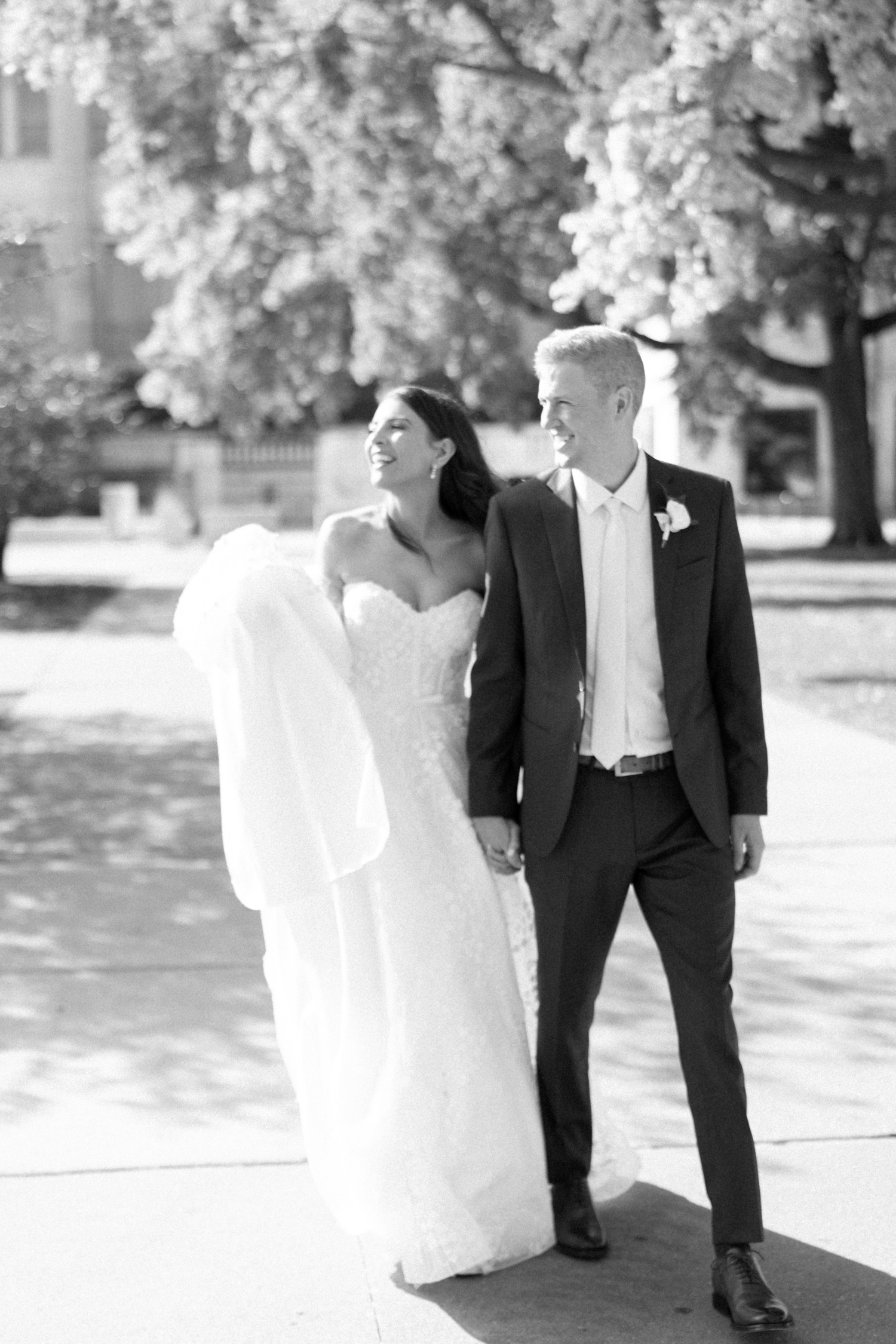 Bride and groom walking and smiling at Revel motor row weddings, photography by Allison Francois