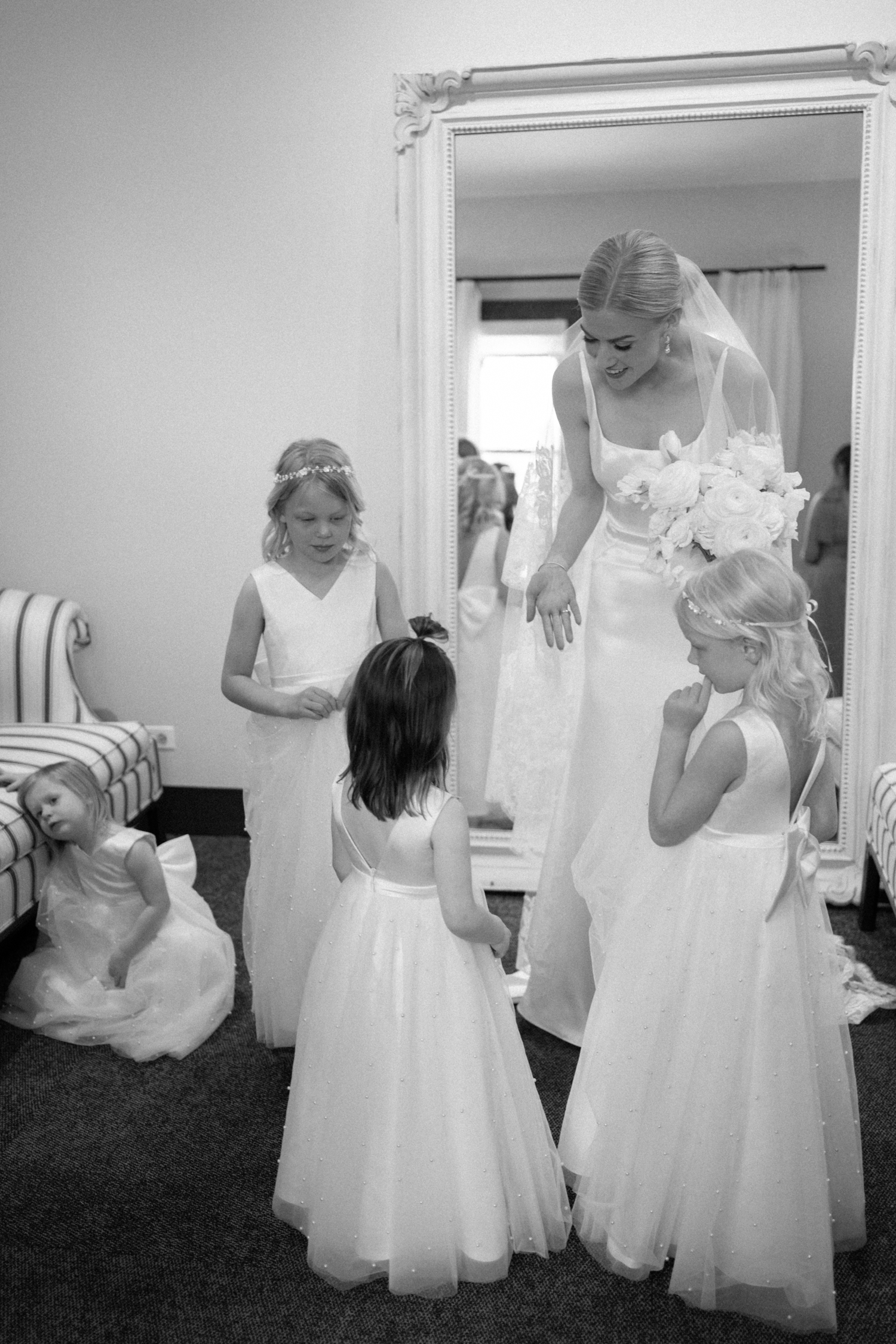 bride surrounded by flower girls at her wedding 