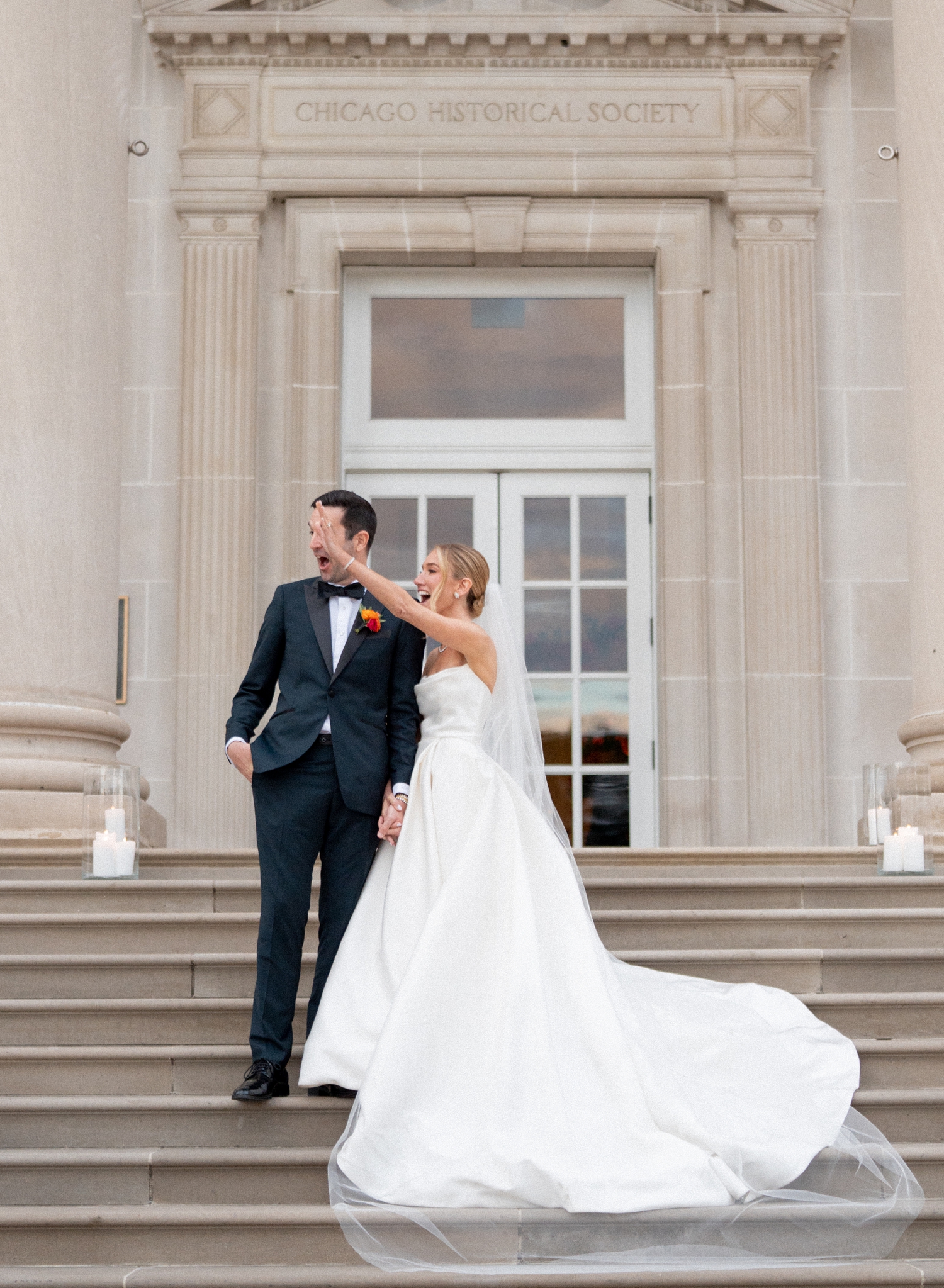 Bride and groom waving at guests for chicago history museum wedding photos​
